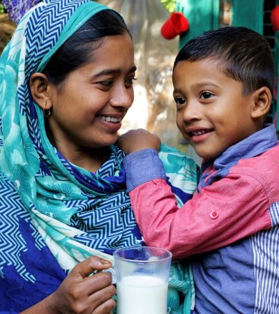 A mother feeds her son milk produced by her family’s dairy cows
