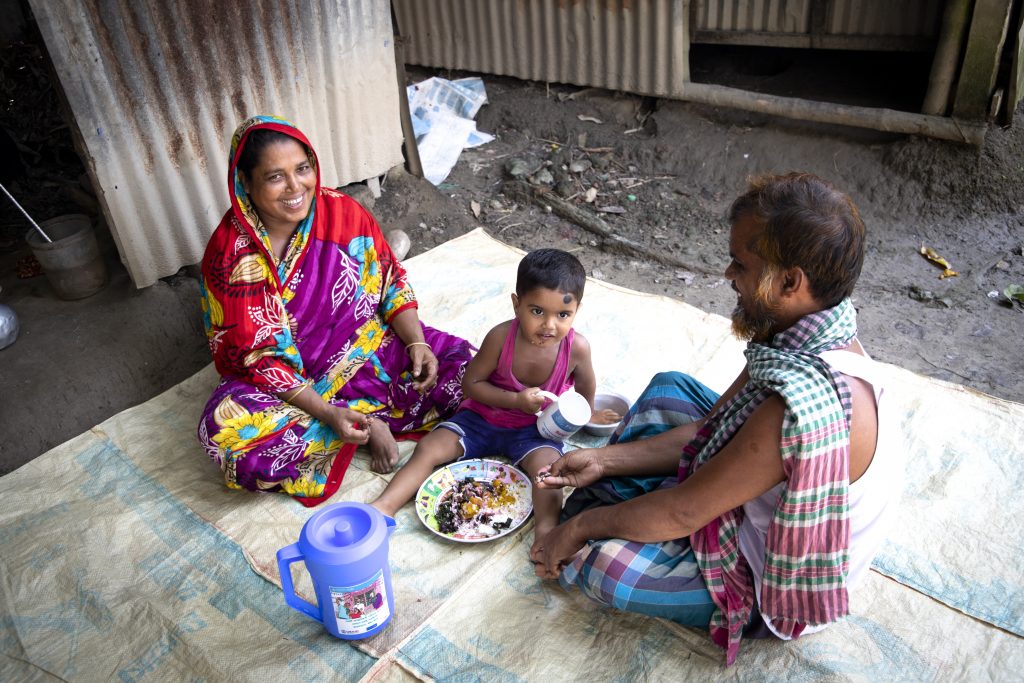 Feroza feeding home-grown vegetables to her grandson.